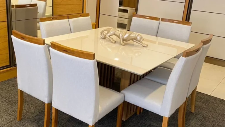 Uma mesa de vidro com um tampo branco leitoso e cadeiras.